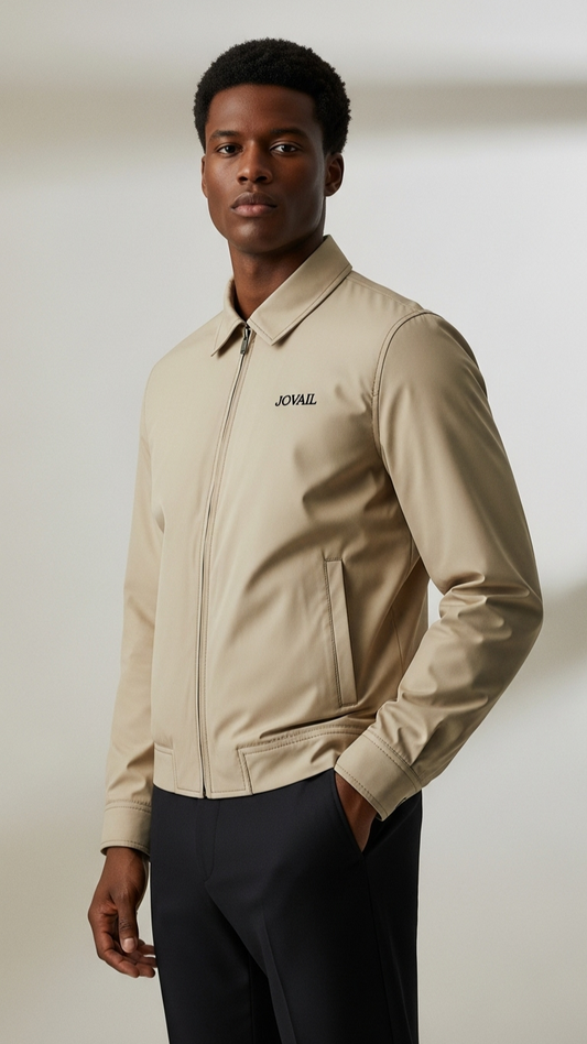 Man wearing a beige jacket with a brand logo on a plain background