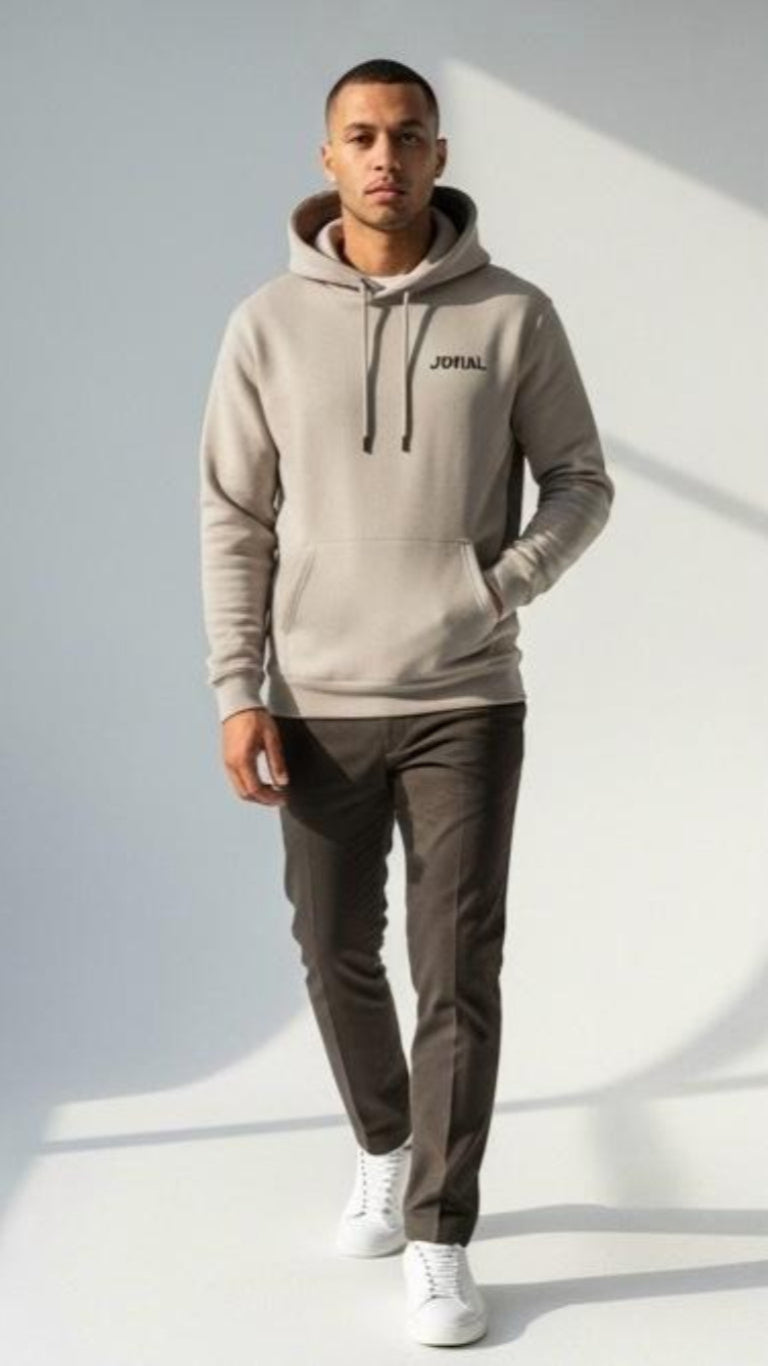 Man wearing a beige hoodie with 'Jovail' branding on a light gray background